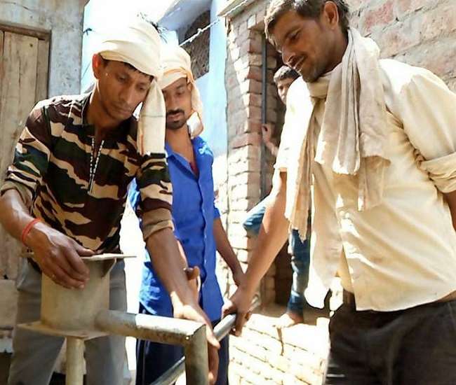 अलीगढ़ में खराब हैंडपंप को सुधारते कर्मचारी।