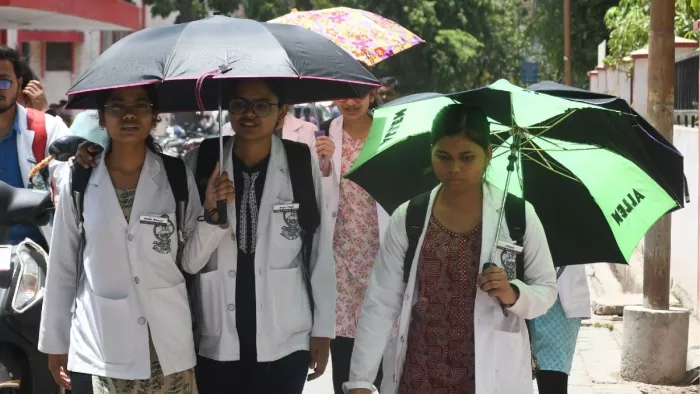 तेज धूप और लू के बीच एलएलआर अस्पताल में छाते के सहारे क्लास करने जातीं मेडिकल छात्राएं। जागरण