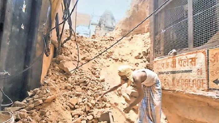 दशाश्वमेध के खालिसपुरा क्षेत्र में गिरे मकान का मलबा हटाता श्रमिकl जागरण