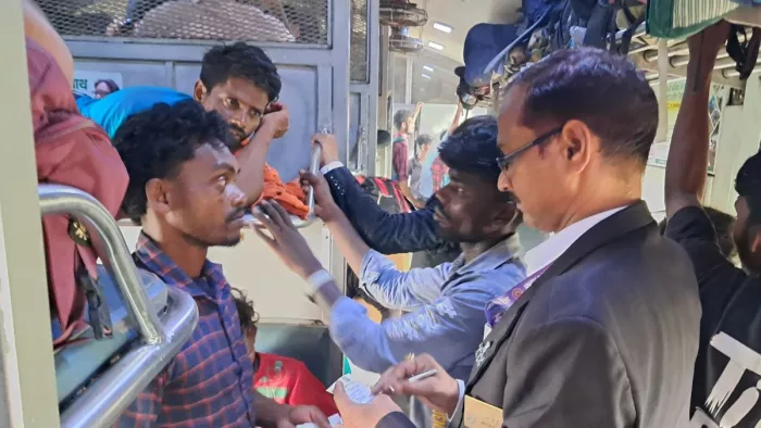 ट्रेन में टिकट की जांच करते टीटीई