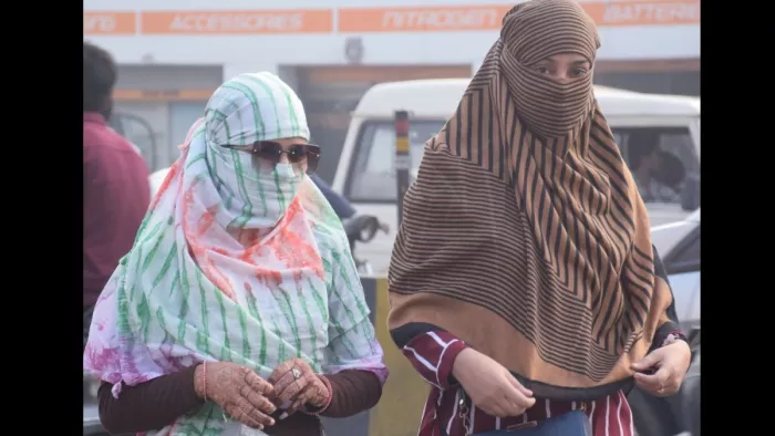 सर्द हवा से बचने के लिए चेहरे पर कपड़ा बांधकर जाती युवतियां। जागरण