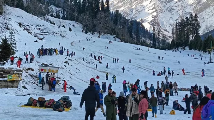 मनाली के पर्यटन स्थल सोलंग नाला में बर्फ के बीच मस्ती करते पर्यटक
