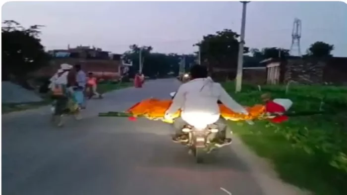 कौशांबी में इंटरनेट मीडिया पर प्रसारित वीडियो में बाइक से शव ले जाते लोग।