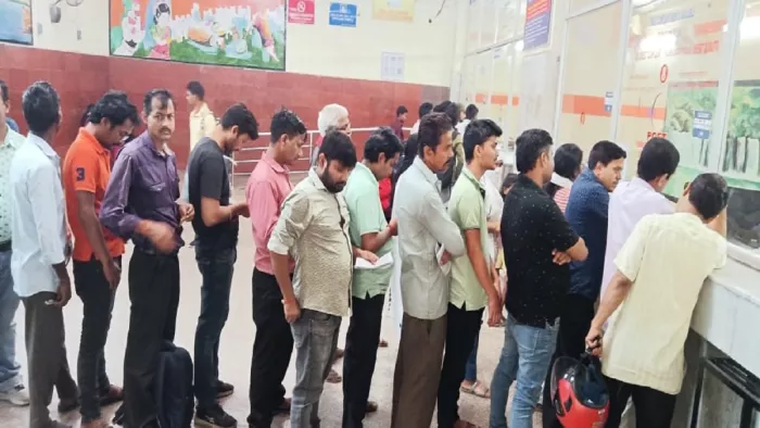 तत्काल टिकट के लिए कतार में खड़े टिकट दलालों की टोली उसके पीछे आम लोग।