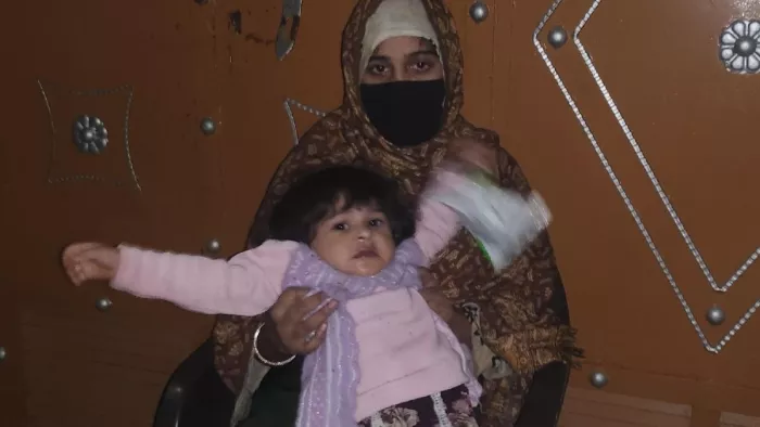 बड़ौत के बिजरौल गांव में मकान के बाहर बच्ची को लेकर बैठी पीड़ित महिला। जागरण