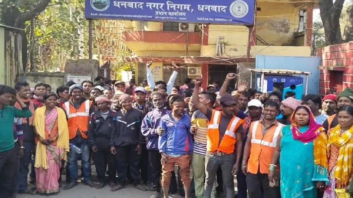 धनबाद नगर निगम के गेट के सामने प्रदर्शन करते कर्मचारी