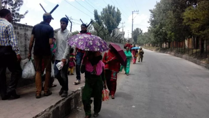 गर्मी से बचने के लिए छाता लगाकर जाते लोग (फाइल फोटो)