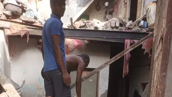 इमारत गिरने के बाद मलबा हटाते लोग।