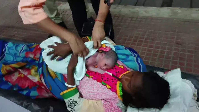 नवजात शिशु को अस्पताल ले जाते चिकित्सा कर्मी