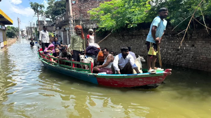 Mathura Flood Update: यमुना नदी का पानी बढ़ने से नाव से लोग निकल रहे हैं।