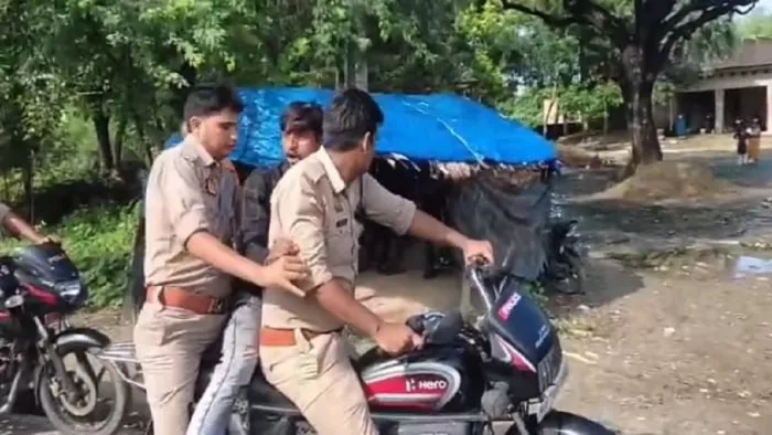 ट्रैफिक नियम का हवाला देकर पिटाई कर बाइक सवार को पकड़कर ले जातेे बिना हेलमेट लगाए पुलिसकर्मी।सौजन्य : इंटरनेट मीडिया