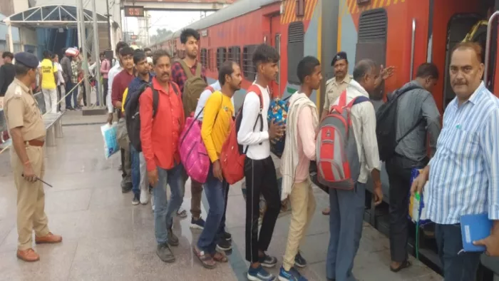 रेलवे स्टेशन पर लाइन में लगकर गोरखधाम एक्सप्रेस ट्रेन में बैठते यात्री।