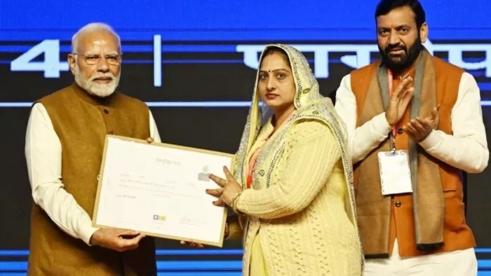 बीमा सखी राखी त्यागी को नियुक्ति पत्र सौंपते हुए पीएम मोदी।