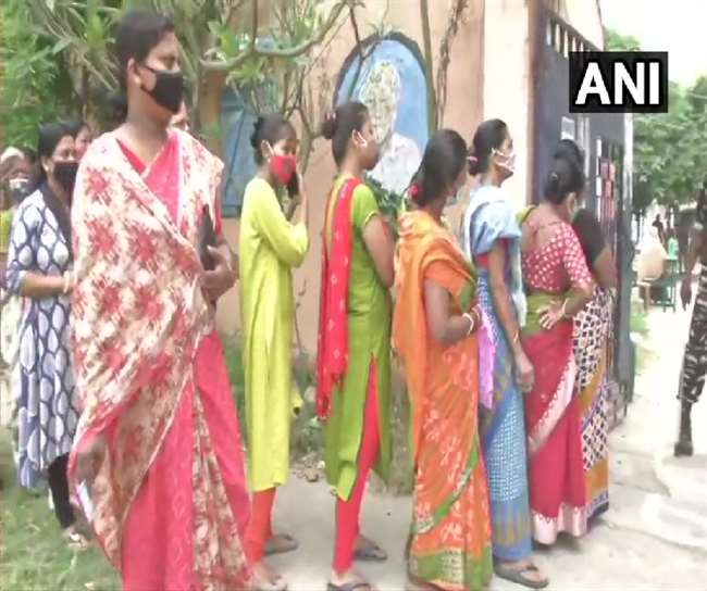 मतदान केंद्र पर वोट डालने के लिए लाइन पर लगी महिलाएं