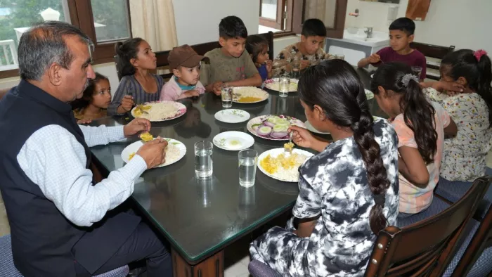 मुख्यमंत्री सुखविंदर सिंह सुक्खू सराज में राहत कैंप में बच्चों के साथ खाना खाते हुए।