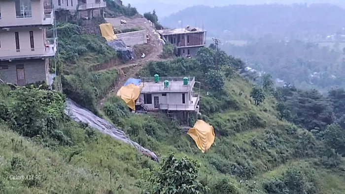 जोगिंदरनगर के ढेलू मुहाल में पहाड़ी पर स्थित बहुमंजिला इमारतों पर भूस्खलन का खतरा मंडरा रहा है (फोटो: जागरण)