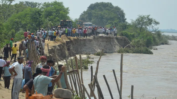 बिजनौर में तटबंध पर तेजधार से हो रहे कटान के दौरान काम में जुटे श्रमिक व ग्रामीण। जागरण
