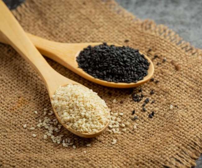 सर्विंग स्पून में रखे काले व सफेद तिल