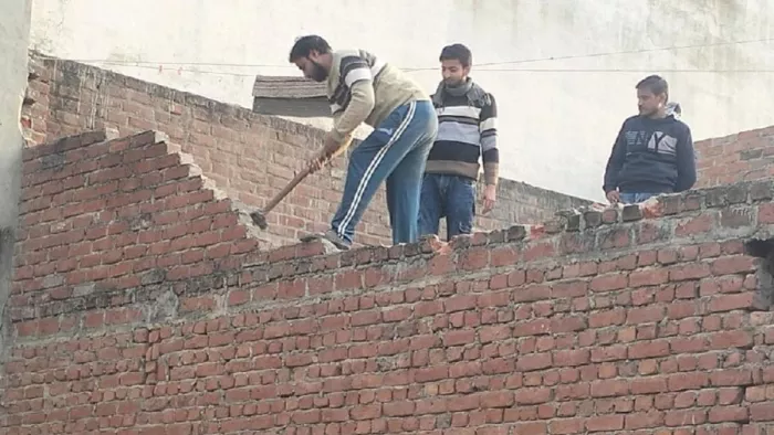चंदौसी लक्ष्मणगंज स्थित बावड़ी परिसर में आ रहे मकान को स्वंय तोड़ते हुए। जागरण