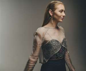 डिज़ाइनर आउटफिट और स्लीक हेयर स्टाइल में मॉडल