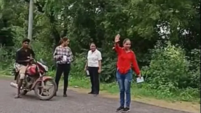वाहन रोकने के लिए हाथ दिखातीं युवती व बाइक रोक कर खड़ीं उसकी साथी दो युवतीं। वीडियो ग्रैव