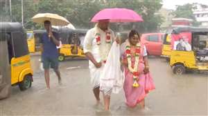 तमिलनाडु में बारिश के चलते छाता लेकर शादी करने पहुंचा जोड़ा।