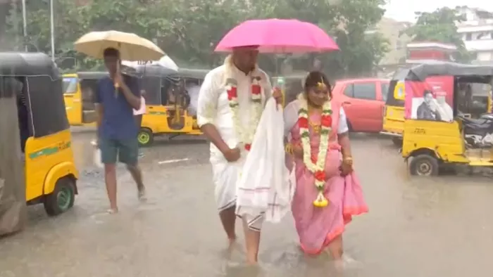 तमिलनाडु में बारिश के चलते छाता लेकर शादी करने पहुंचा जोड़ा।