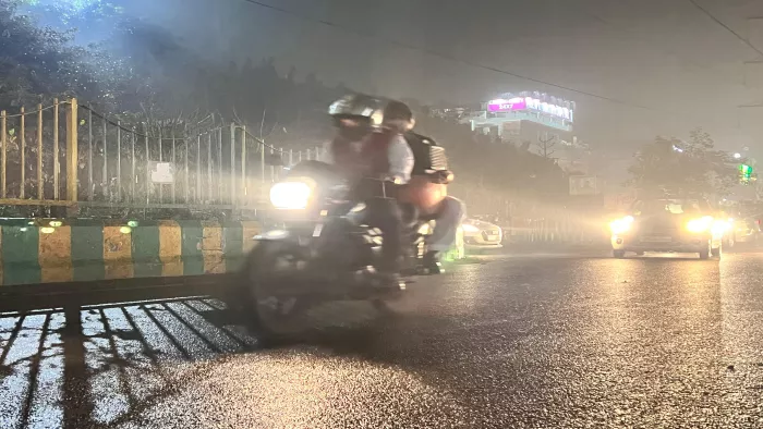 बारिश से बीच बाइक से गुजरते युवक। फोटो- जागरण