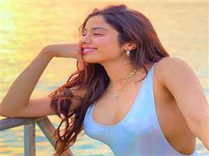 फोटो में जाह्नवी कपूर समुद्र किनारे बैठी हुई हैl