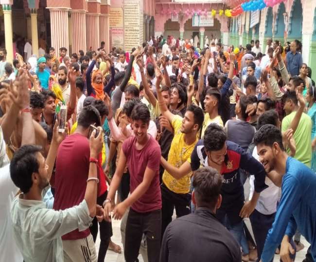 बलदाऊ के जन्मदिन पर बल्देव के मंदिर में नृत्य करते युवा।
