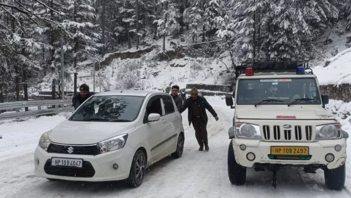 शिमला के सनाबा-बगोली में हिमपात के बाद फंसे वाहन को निकालने में जुटे पुलिस जवान (फोटो- जागरण)