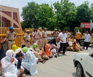 भाजपा की बैठक के दौरान धरने पर बैठे किसान। पीछे तैनात सिविल लाइन थाना प्रभारी विक्रम सिंह। (फाइल फोटो)
