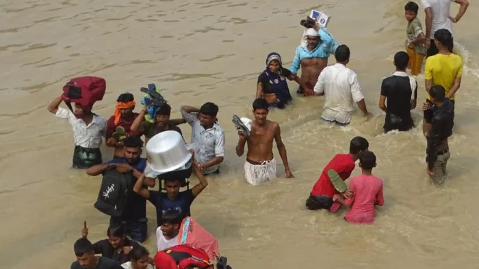 शाहजहांपुर में बाढ़ का पानी घरों में घुसा है, आवास विकास कॉलोनी से अपना सामान लेकर आते लोग l जागरण