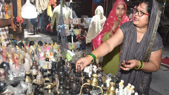 परमट स्थित आनंदेश्वर मंदिर परिसर में लगी दुकान में खरीदारी करतीं महिलाएं। जागरण