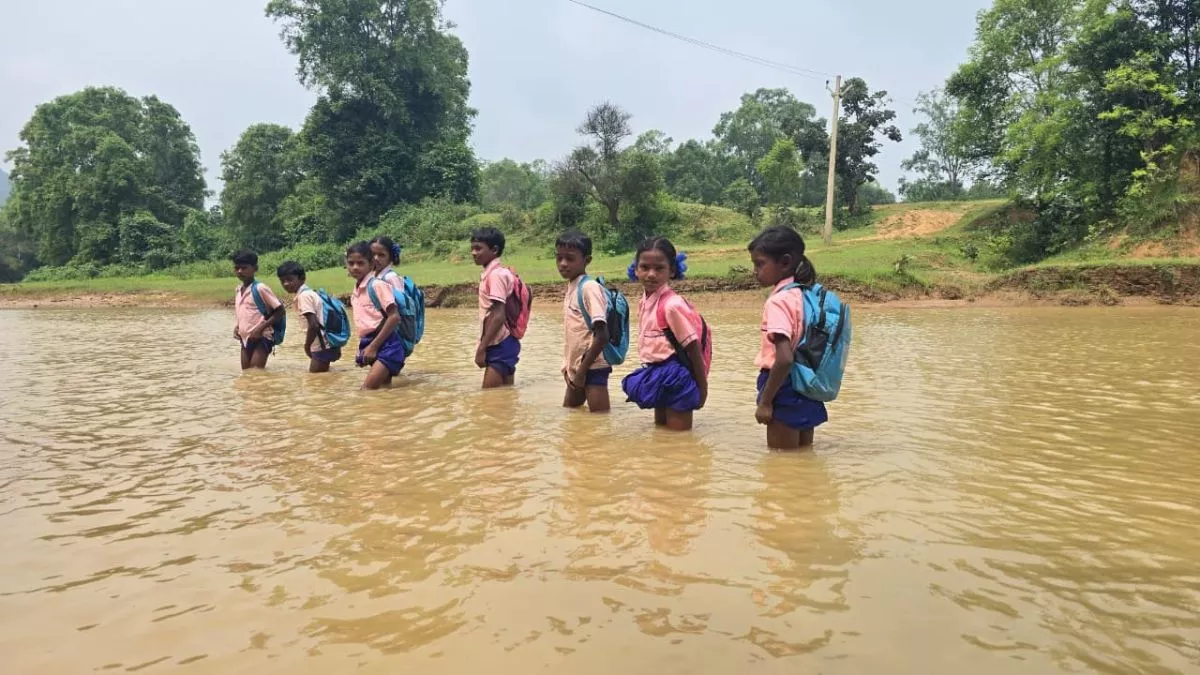 Jharkhand News: बारिश में पुल व पक्की सड़क न होने से परेशान बच्चे, नाला पार कर जा रहे स्कूल