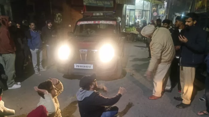 नशे में धुत युवक पुलिस के वाहन के आगे बैठ प्रदर्शन करते हुए