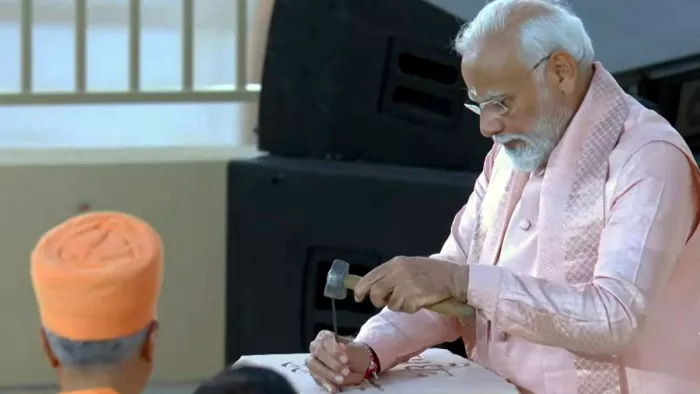 पीएम मोदी ने मंदिर में हथौड़े और छेनी का उपयोग करके पत्थर पर ''वसुधैव कुटुंबकम'' भी अंकित किया। (फोटो- एपी)