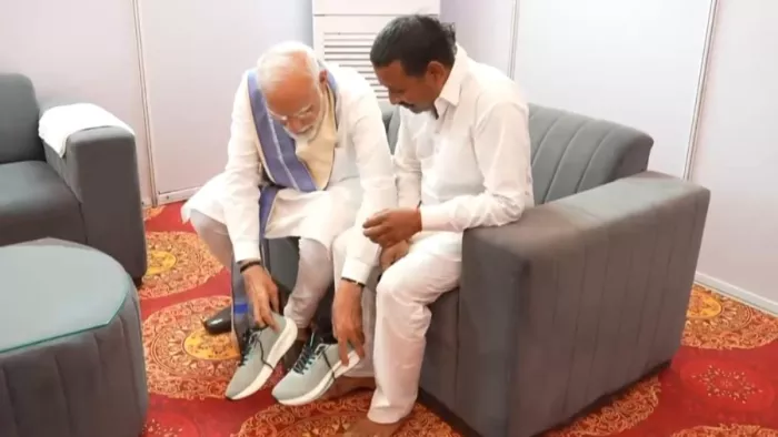 रामपाल कश्यप को PM मोदी ने पहनाए जूते। फोटो जागरण