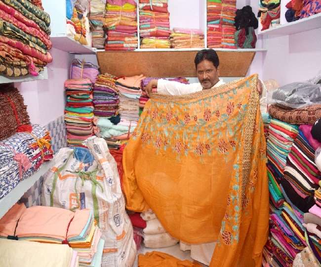 छोटे मियां का हाता के कपड़ा व्यापारी नूर अली अपनी दुकान पर साडि़यां और सूट तौलकर बेचते है। जागरण