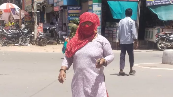 महावीर चौक नारनौल से सिंघाना रोड की तरफ तेज धूप से बचाव करके जाती हुई महिला।जागरण