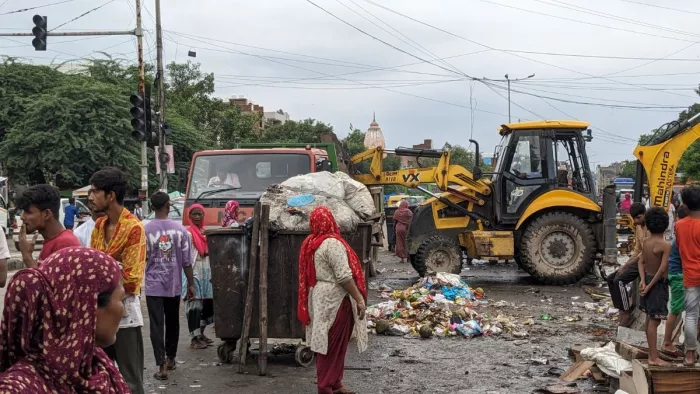 सीमापुरी में कार्रवाई के दौरान कबाड़ को उठाकर ट्रक में डालता बुलडोजर। फोटो नगर निगम