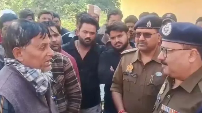 Badaun News: हत्या की जानकारी पिता से लेते पुलिस अधिकारी।