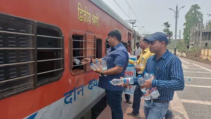 विक्रमशिला एक्सप्रेस के यात्रियों के बीच पानी का वितरण करते संस्था के लोग (फोटो- जागरण)