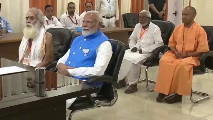 नामांकन कक्ष में प्रस्तावकों के साथ बैठे प्रधानमंत्री नरेंद्र मोदी। सूचना विभाग