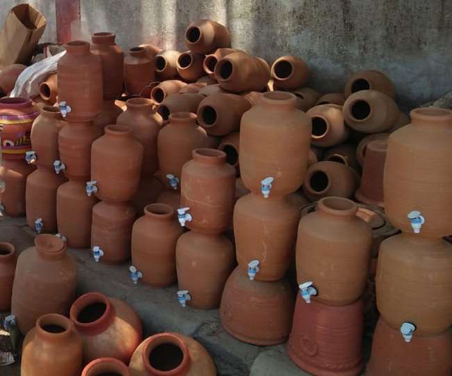 Tall slender porcelain bottle with natural clay textured body and cork stopper.