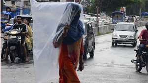 दोपहर बाद हुई वर्षा के चलते जीएमएस रोड के समीप इस तरह वर्षा से बचकर जाती महिला। जागरण