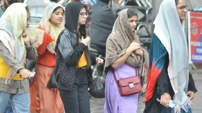 अमृतसर में हुई बूंदाबांदी में गर्म कपड़े पहन सर्दी से बचाव करतीं युवतियां। (राघव शिकारपुरिया)