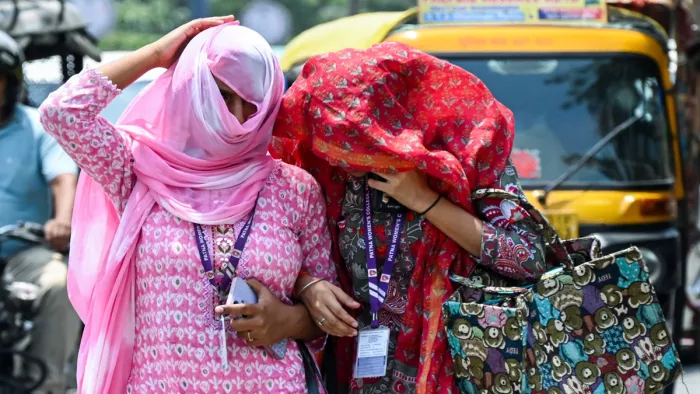 गुरुवार को पटना में भीषण गर्मी से बचने के लिए महिलाएं सिर पर स्कार्फ बांधती हुई। (फोटो- एएनआई)