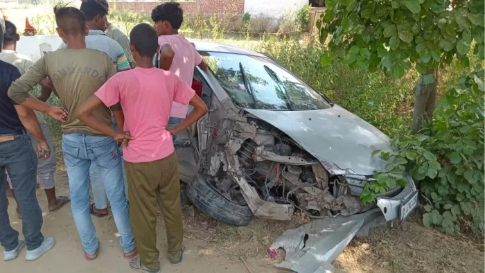 हादसे के बाद क्षतिग्रस्त कार देखते लोग।