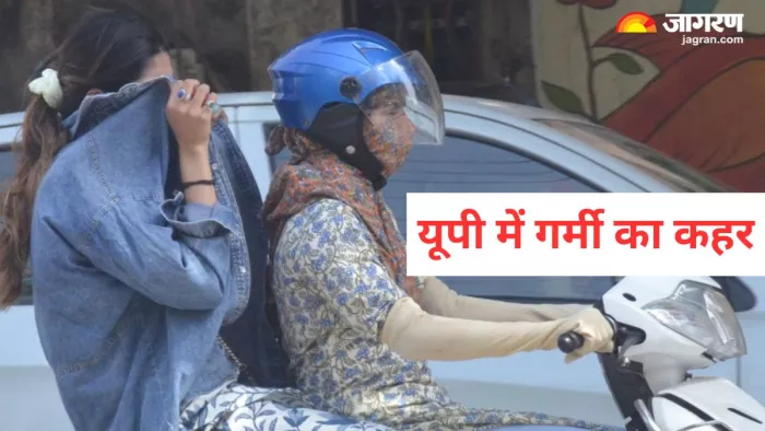 आगरा: हरीपर्वत चौराहे पर लू के थपेड़ों से खुद को बचाने का प्रयास करती स्कूटी सवार युवती। जागरण